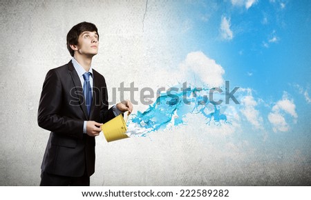 Young businessman holding in hands yellow bucket