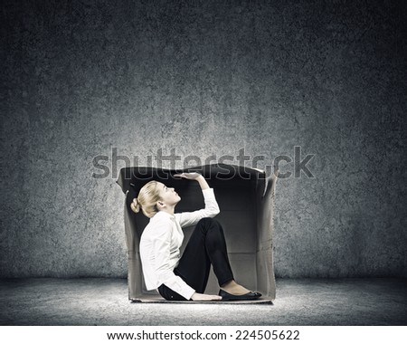 Young businesswoman trapped in carton box