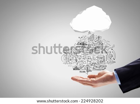 Close up of businessman hand holding cloud with business sketches
