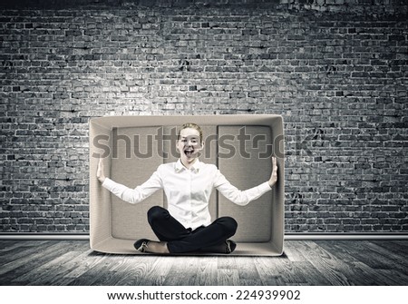 Young emotional woman trapped in carton box