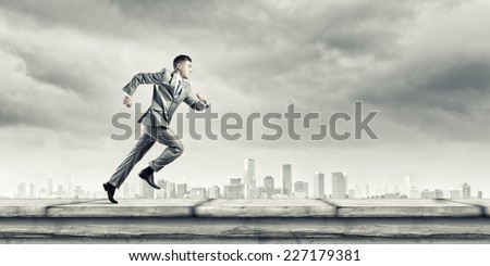 Young running businessman with colorful splashes in hand