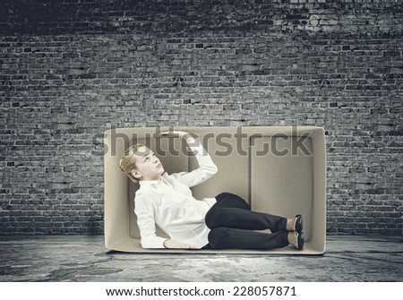 Young businesswoman trapped in carton box