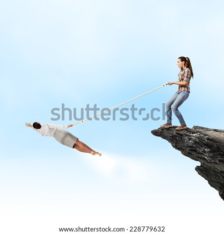 Woman holding on rope businesswoman trying to escape