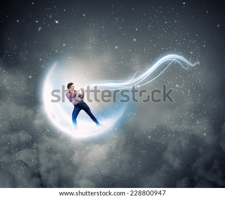 Young man in casual catching moon with rope