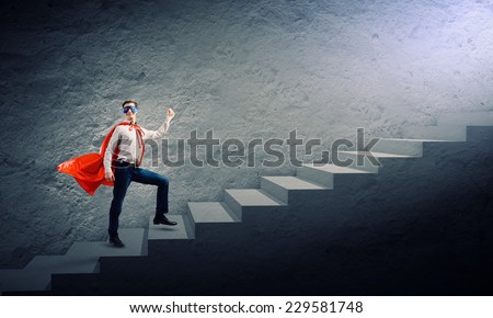 Young superman walking up the stair case