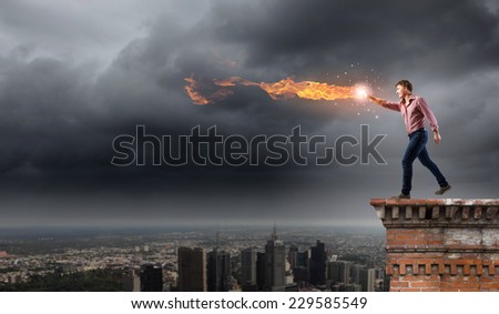 Young man in casual throwing magic fire balls