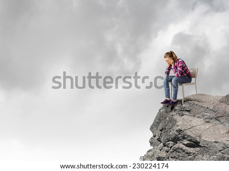 Young thoughtful woman in casual sitting in chair