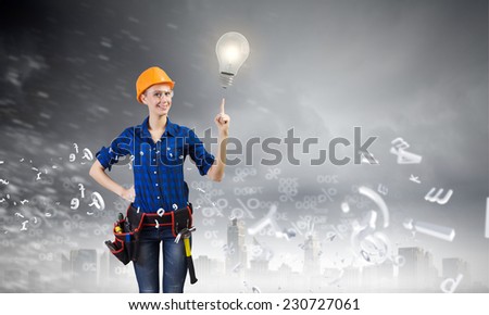 Young woman handyman pointing at electrical bulb
