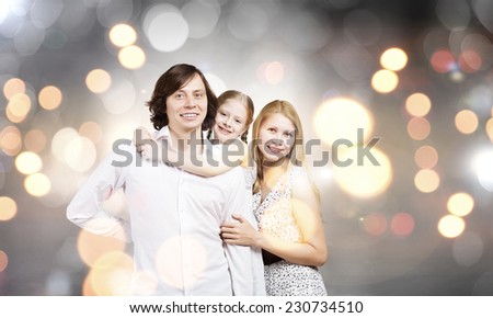 Happy family of mother father and daughter against bokeh background