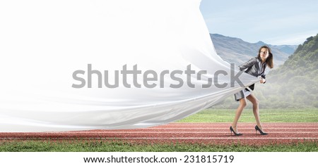 Young businesswoman in suit running on stadium track. Place for text