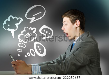 Young emotional businessman looking shocked in tablet pc