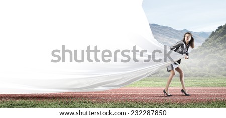 Young businesswoman in suit running on stadium track. Place for text
