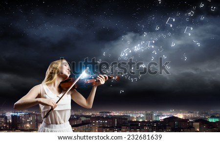 Young woman in white dress playing violin