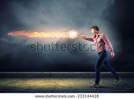 Young man in casual throwing magic fire balls