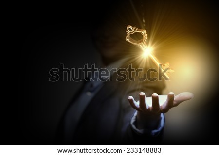 Close up of businesswoman holding golden key in hand