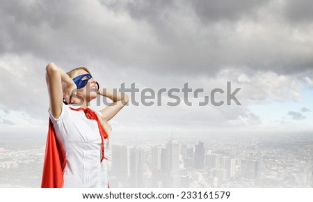 Young confident woman in red cape and mask
