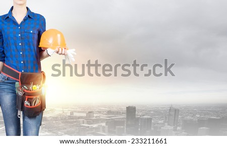 Close up of woman builder with hardhat in hands