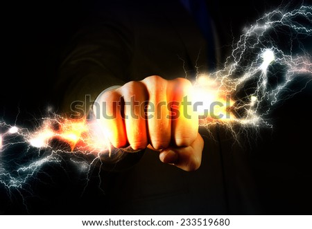 Close up of businessman grasping lightning in hand