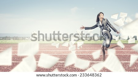 Young businesswoman in suit running on stadium track