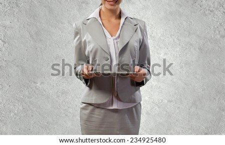 Young attractive woman in suit with tablet pc in hands