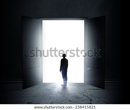 Rear view of businessman standing in light of opened door