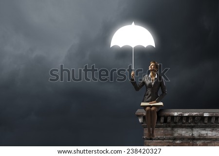 Young businesswoman sitting on top of building with book