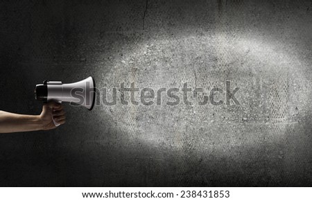 Close up of human hand holding megaphone