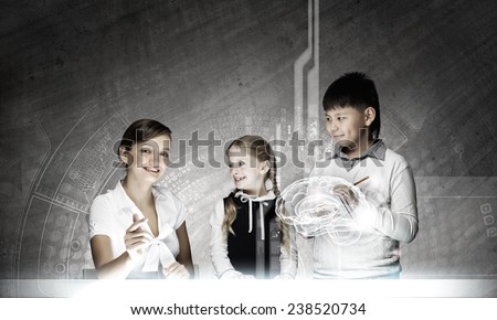 Young teacher and her pupils examining hologram of human brain