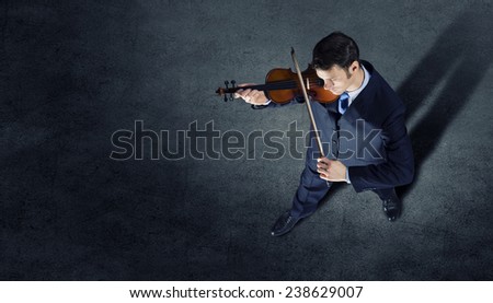 Top view of young businessman playing violin