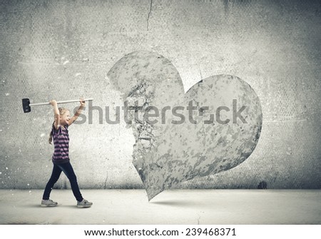Cute girl breaking stone heart with hammer