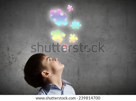 Young boy of school age looking at puzzle elements