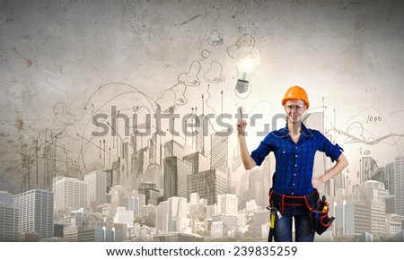 Young woman handyman pointing at electrical bulb