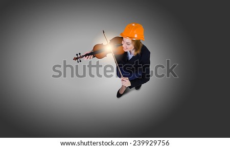 Top view of businesswoman in helmet playing violin