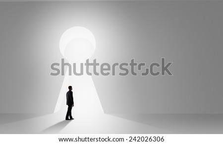 Back view of businessman standing in keyhole doorway