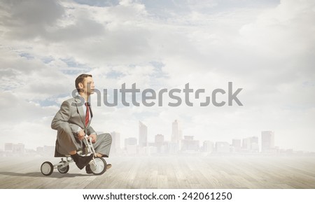 Young handsome businessman riding three wheeled bicycle