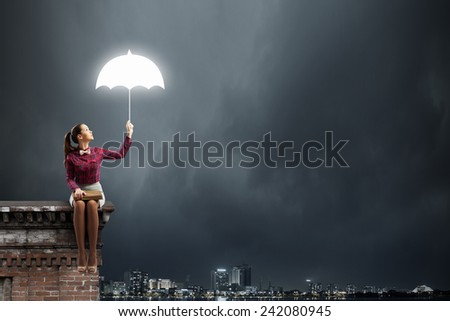 Young beautiful lady sitting on building roof and reading book
