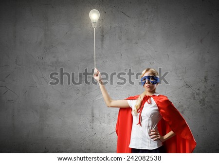 Young woman in super hero costume with bulb balloon in hand