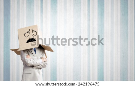 Businessman wearing carton box with drawn emotions on head