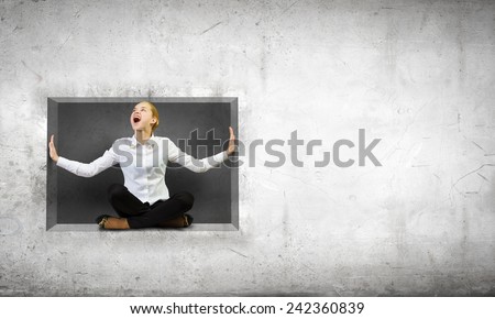 Young woman trapped in stone cube in wall