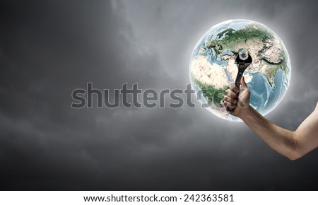 Close up of hand spinning nut on Earth planet. Elements of this image are furnished by NASA