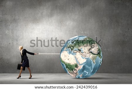 Young businesswoman holding Earth planet on lead. Elements of this image are furnished by NASA