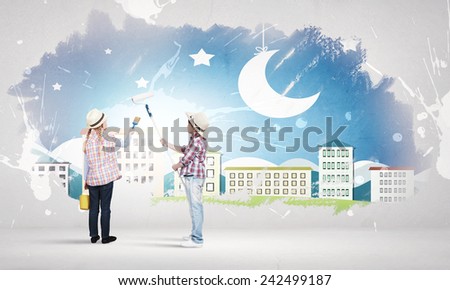 Two children of school age painting wall with roller