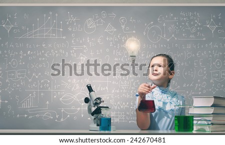 Cute girl at chemistry lesson making tests