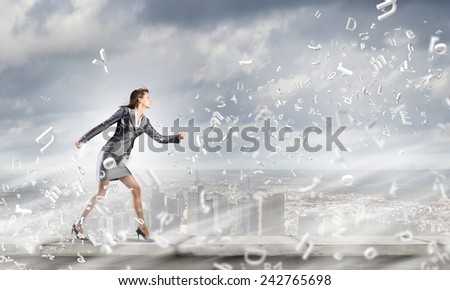 Young pretty businesswoman in suit running away