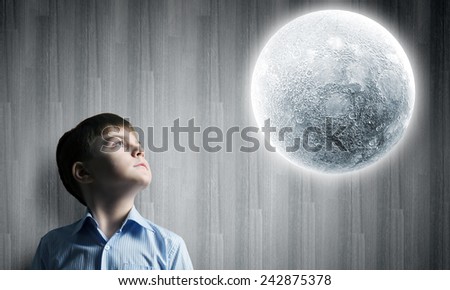 Cute boy of school age looking at moon
