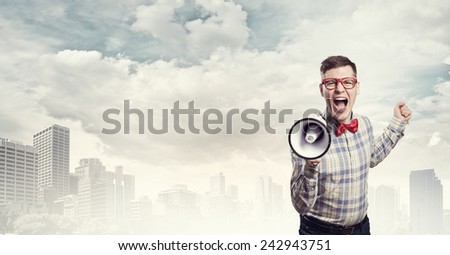 Young funny man screaming emotionally in megaphone