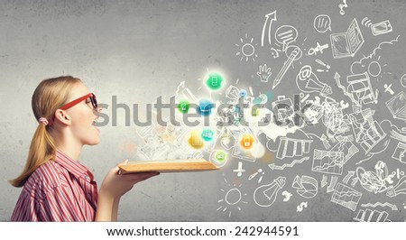 Young funny girl with opened book in hands