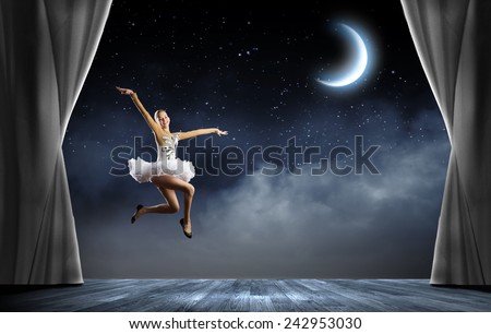 Young pretty ballerina girl making jump in dance