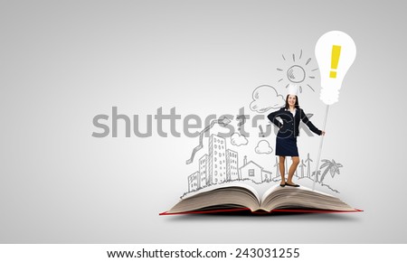 Young businesswoman in paper crown standing on book