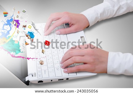 Hands of businessman using laptop and colorful splashes on screen